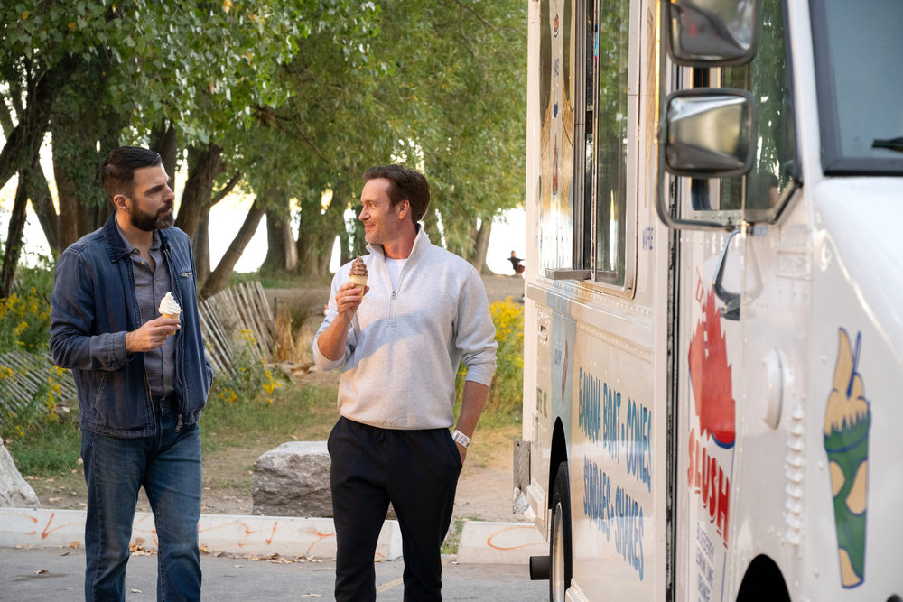 Brilliant Minds - Oliver and his patient and friend Tom are walking side by side while eating an ice cream