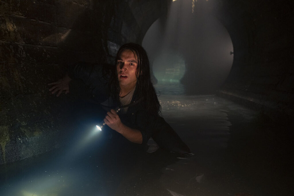 Taniel is escaping in the sewers, a flashlight in his hand